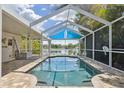 Screened-in pool overlooking the lake features a covered area offering shade for relaxing and enjoying the water view at 12038 Steppingstone Blvd, Tampa, FL 33635