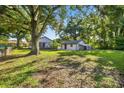 Spacious backyard surrounded by mature trees with a detached garage and an old-Florida style home at 1217 E 29Th Ave, Tampa, FL 33605