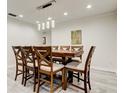 Dining room featuring an extending wooden table with seating for eight and modern light fixtures at 1402 Provincetown Cir, Lutz, FL 33549