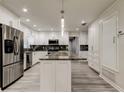 Modern kitchen featuring stainless steel appliances, a kitchen island, and sleek white cabinetry at 1402 Provincetown Cir, Lutz, FL 33549