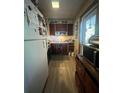 Narrow kitchen featuring wood cabinets, white refrigerator, and lots of natural light at 1420 36Th N Ave, St Petersburg, FL 33704