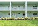 Three story building with light blue painted facade, railings and green grass at 1706 Belleair Forest Dr # 146, Belleair, FL 33756