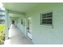 Hallway to unit with light blue painted exterior, concrete floor, and large window at 1706 Belleair Forest Dr # 146, Belleair, FL 33756