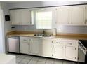 Classic kitchen featuring white cabinets, stainless steel appliances, and a double sink at 1706 Belleair Forest Dr # 146, Belleair, FL 33756