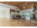 Cozy living room featuring a stone fireplace, wood ceiling, hardwood floors, and sliding glass doors at 18110 30Th St, Lutz, FL 33559