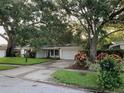 Inviting single-story home with a lush lawn, colorful landscaping, and a neatly maintained driveway at 1861 Harmony Dr, Clearwater, FL 33756