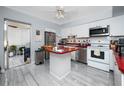 Bright kitchen with white cabinetry, stainless steel appliances, and a convenient island at 211 Pasadena N Ave # 109, St Petersburg, FL 33710