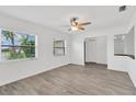 Bright living room featuring new flooring, fresh paint, and a modern ceiling fan at 2325 W Knollwood Pl, Tampa, FL 33604