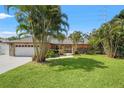 Landscaped front yard with mature trees and a well-maintained lawn leading to the home's entrance at 2708 W Bird St, Tampa, FL 33614