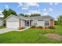 Well-maintained single-story house with gray siding, brick accents, and lush green lawn at 2868 Denmarsh Ct, Palm Harbor, FL 34684