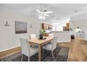 Cozy dining area showcasing a modern table set, an elegant ceiling fan, and wood-look flooring at 30260 Birdhouse Dr, Wesley Chapel, FL 33545