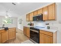 Well-lit kitchen featuring wood cabinetry, sleek appliances, plenty of counter space, and wood-look flooring at 30260 Birdhouse Dr, Wesley Chapel, FL 33545
