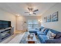 Comfortable living room with modern ceiling fan, light wood floors, and lots of natural light at 367 Countryside Key Blvd, Oldsmar, FL 34677