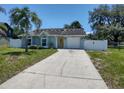 Well-maintained single-story home with arched windows, yellow door, attached garage, and concrete driveway at 4707 Barrett Ct, Tampa, FL 33617