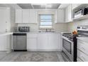Cozy kitchen features white cabinets, stainless steel appliances, and a bright window over the sink area at 4775 Cove Cir # 803, St Petersburg, FL 33708