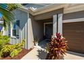 Inviting front entrance with decorative plants, dark front door, and a well-lit porch at 4906 Los Robles Ct, Palmetto, FL 34221