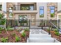 Close-up of a modern townhome entrance with stone accents, a black metal fence, and landscaped garden at 50 64Th S St, St Petersburg, FL 33707
