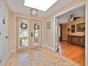 Welcoming foyer featuring tile flooring, decorative wreath doors and a view of the living room at 6207 Ridge Top Dr, New Port Richey, FL 34655