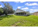 Spacious backyard featuring a well-maintained lawn, screened-in porch, and white fence at 6318 Ashfield Pl, Wesley Chapel, FL 33545
