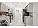 Functional kitchen with stainless steel appliances, white cabinets, and mosaic backsplash at 6318 Ashfield Pl, Wesley Chapel, FL 33545