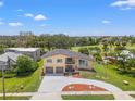 Stunning aerial view of a two-story home with a pool, golf course, and lush landscaping at 6780 Greenbrier Dr, Seminole, FL 33777