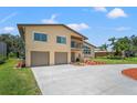 Beautiful tan two-story home with a two-car garage, balcony, and lush landscaping at 6780 Greenbrier Dr, Seminole, FL 33777