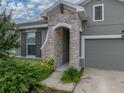 Close up shot of the exterior entrance with green bushes and stone archway at 8119 Trimbelle Ter, Parrish, FL 34219