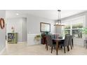 Dining area featuring a modern light fixture, neutral walls, and a window providing natural light at 9275 Bella Vita Cir, Land O Lakes, FL 34637