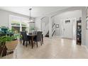 Open dining area with views of the entryway, staircase, and a bright window at 9275 Bella Vita Cir, Land O Lakes, FL 34637