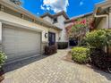 Stunning home exterior with multi-car garage, brick driveway, manicured bushes, and front door at 9808 Milano Dr, Trinity, FL 34655
