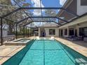 Enjoy the sparkling pool and spa surrounded by a screened enclosure and travertine tile deck at 9808 Milano Dr, Trinity, FL 34655