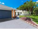 Home exterior highlighting a modern two-car garage and landscaping, with palm trees adding a tropical touch at 13710 Westshire Dr, Tampa, FL 33618