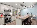 Well-equipped kitchen featuring stainless steel appliances, granite countertops, and a cozy breakfast bar at 14030 79Th Ave, Seminole, FL 33776