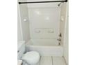Clean white tiled bathroom features a shower and tub combo with built-in shelves at 14442 Reuter Strasse Cir # 812, Tampa, FL 33613