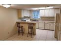 Cozy kitchen features tile floors, an island with seating, and white appliances at 14442 Reuter Strasse Cir # 812, Tampa, FL 33613