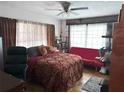 Comfortable bedroom with ample natural light and unique decor, featuring a ceiling fan and warm tones at 1448 Temple St, Clearwater, FL 33756