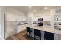 Modern kitchen with white cabinets, granite countertops, stainless steel appliances, and breakfast bar seating at 14710 Italy Ave, Dade City, FL 33523