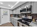 This remodeled kitchen features stainless steel appliances, gray cabinets and subway tile backsplash at 1485 Lakeview Rd # 2, Clearwater, FL 33756