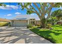 Charming home featuring a lush landscaped front yard, driveway, and a large shade tree at 1531 75Th Ne Cir, St Petersburg, FL 33702