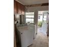 Utility room featuring a washing machine and dryer along with a bright, airy window at 15416 2Nd E St, Madeira Beach, FL 33708