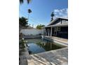 Backyard pool surrounded by brick pavers, overlooked by the rear of the home at 15416 2Nd E St, Madeira Beach, FL 33708