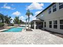 Beautiful backyard featuring a sparkling pool, paved patio, and outdoor seating area with an elegant pergola at 1669 Feather Grass Loop, Lutz, FL 33558