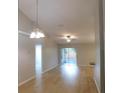 Bright living room with vaulted ceiling, modern light fixture, and sliding glass doors at 2114 Intervista Ln, Valrico, FL 33594