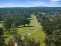 Breathtaking aerial view showcasing a lush green golf course surrounded by mature trees at 23327 Christian Cir, Brooksville, FL 34601