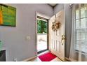 Bright entryway showcasing an open door with a screen, a red rug, and view of the front terrace at 269 Los Prados Dr # 1011, Safety Harbor, FL 34695
