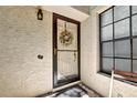 Close-up of the front door with a decorative wreath, a storm door, and secure entry at 269 Los Prados Dr # 1011, Safety Harbor, FL 34695