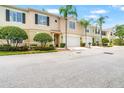 Attractive townhome showcases a two-car garage, manicured landscaping, and lovely palm trees at 3519 Heards Ferry Dr, Tampa, FL 33618