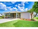Well-manicured lawn and landscaped yard complements the covered parking of this cozy home at 37526 New Horizons Blvd, Zephyrhills, FL 33541