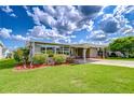 Inviting home with covered parking and colorful, professionally landscaped yard at 37526 New Horizons Blvd, Zephyrhills, FL 33541