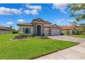 Beautiful front exterior features a three-car garage and tiled roof, situated on a well-manicured lawn at 3999 Burdick Loop, Odessa, FL 33556